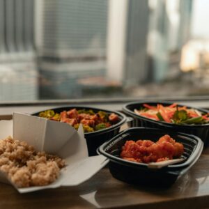 Enjoy a delicious Asian takeout meal with a stunning view of Miami's skyline from a high-rise window.